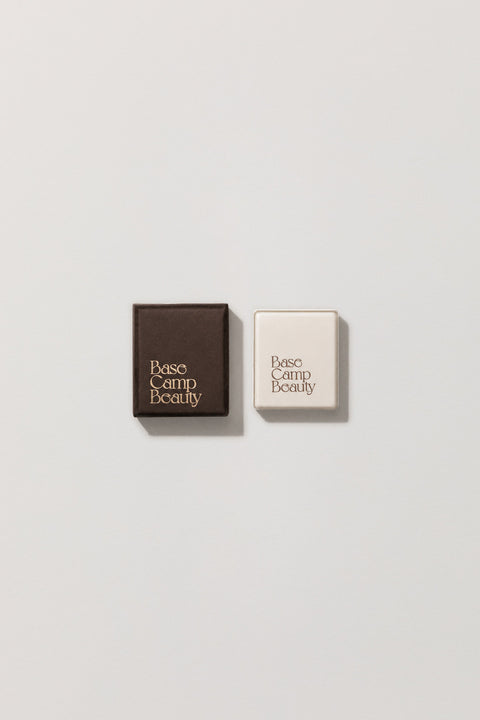 Pencil sharpener and carton with 'Base Camp Beauty' branding on a light grey background